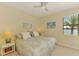 Cozy bedroom with a ceiling fan, a window with a view, and neutral decor at 20370 Grazie Pl, Venice, FL 34293