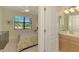 Comfortable bedroom with a view to the outside and an ensuite bath at 20370 Grazie Pl, Venice, FL 34293