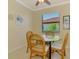 Cozy breakfast nook features a glass table, wicker chairs, and natural light at 20370 Grazie Pl, Venice, FL 34293