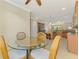 Open-concept dining area adjacent to the kitchen, featuring a round glass table and wicker chairs at 20370 Grazie Pl, Venice, FL 34293