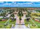 Aerial view of a community entrance featuring manicured landscaping, palm trees, and a well-designed road layout at 20370 Grazie Pl, Venice, FL 34293