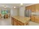 Bright kitchen features an island with granite countertops, stainless steel refrigerator, and eat-in area at 20370 Grazie Pl, Venice, FL 34293