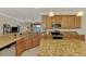 Modern kitchen with granite countertops, stainless steel appliances, and views of the lake at 20370 Grazie Pl, Venice, FL 34293