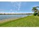 Scenic lake view with grassy shoreline, offering a peaceful and natural setting near residential properties at 20370 Grazie Pl, Venice, FL 34293