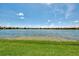 Picturesque view of a serene lake surrounded by well-manicured green space and a distant residential community at 20370 Grazie Pl, Venice, FL 34293