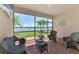Enclosed lanai with brick flooring, wicker furniture, and beautiful water views at 20370 Grazie Pl, Venice, FL 34293
