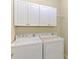 Laundry room with a washer, a dryer, and white cabinets for storage at 20370 Grazie Pl, Venice, FL 34293