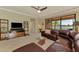 Spacious living room featuring water view, ceiling fan, and comfortable leather sofa at 20370 Grazie Pl, Venice, FL 34293