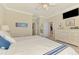 Bright main bedroom featuring a ceiling fan, TV, and dresser, plus access to an organized walk-in closet at 20370 Grazie Pl, Venice, FL 34293