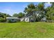 Spacious backyard with a well-maintained lawn, storage shed, and mature trees at 2185 Park Rd, Venice, FL 34293