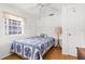 Comfortable bedroom with a blue patterned bedspread, ceiling fan, natural light, and a side table at 2185 Park Rd, Venice, FL 34293