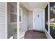 Inviting enclosed front porch featuring a pastel blue door, wood floors and white trim at 2185 Park Rd, Venice, FL 34293