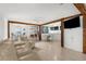 Spacious living area featuring an open layout, white floors, neutral paint, and natural wood beams at 2185 Park Rd, Venice, FL 34293