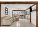 Open-concept living room with exposed wood beams, white walls, and light wood floors at 2185 Park Rd, Venice, FL 34293