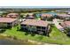 Aerial view of a residential neighborhood with lake views, well-maintained landscaping, and tile roofs at 23527 Awabuki # 202, Venice, FL 34293