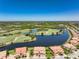 Enjoy an aerial view of a lush green golf course, and properties nestled along the water at 23527 Awabuki # 202, Venice, FL 34293