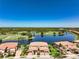 Enjoy an aerial view of a serene lake, a lush green golf course and well landscaped properties at 23527 Awabuki # 202, Venice, FL 34293