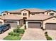Inviting front of a home with a paver driveway, garage and lush, green landscaping at 23527 Awabuki # 202, Venice, FL 34293