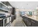 Modern kitchen with dark cabinets, granite countertops, stainless steel appliances and seamless access to the dining area at 23527 Awabuki # 202, Venice, FL 34293