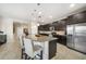 Stylish kitchen with a granite island, dark cabinetry, stainless steel appliances, and tile flooring at 23527 Awabuki # 202, Venice, FL 34293