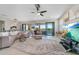 Bright living room features a large sectional, ceiling fan, access to a balcony and stunning water view at 23527 Awabuki # 202, Venice, FL 34293