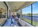 Relaxing screened patio with comfortable seating, scenic lake views, and a dining area for entertaining at 23527 Awabuki # 202, Venice, FL 34293