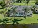 Aerial view of the backyard with a screened-in pool, lush tropical landscaping and a waterfront view at 24339 Matias Ln, Punta Gorda, FL 33955