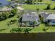 Aerial view of the backyard with a screened-in pool, waterfront view and lush tropical landscaping at 24339 Matias Ln, Punta Gorda, FL 33955