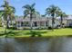 Home exterior showcasing a screened in lanai, waterfront view, and tropical landscaping in the backyard at 24339 Matias Ln, Punta Gorda, FL 33955