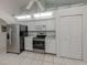 The kitchen has stainless steel appliances, white cabinets, and tile flooring at 24339 Matias Ln, Punta Gorda, FL 33955