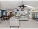 Open-concept living room with high ceilings, a ceiling fan, white couches, and views to the kitchen and dining area at 24339 Matias Ln, Punta Gorda, FL 33955
