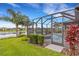 Screened-in lanai provides the perfect outdoor living space overlooking the backyard and lake at 2487 Marton Oak Blvd, North Port, FL 34289