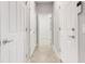 Hallway with tile flooring and white doors creating a bright and clean aesthetic at 2487 Marton Oak Blvd, North Port, FL 34289