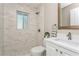 Modern bathroom featuring marble-look shower, white vanity, and sleek fixtures at 26115 Rampart Blvd, Punta Gorda, FL 33983
