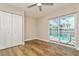 Bedroom with wood-look tile flooring, ceiling fan, closet and sliding glass doors to pool at 26115 Rampart Blvd, Punta Gorda, FL 33983