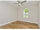 Bright bedroom with wood-look tile flooring, ceiling fan, and natural light from arched window at 26115 Rampart Blvd, Punta Gorda, FL 33983