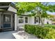 Beautiful front entrance with a decorative glass door and covered porch, surrounded by lush landscaping at 26115 Rampart Blvd, Punta Gorda, FL 33983