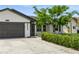 Attractive home featuring a two-car garage, mature landscaping, and a well-manicured lawn at 26115 Rampart Blvd, Punta Gorda, FL 33983