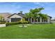 Inviting single-Gathering home showcasing a lush green lawn, mature trees, and a well-kept exterior at 26115 Rampart Blvd, Punta Gorda, FL 33983
