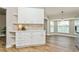 Kitchen with breakfast bar, wood tile floor, and a view through the bay window at 26115 Rampart Blvd, Punta Gorda, FL 33983