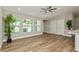 Inviting living room with wood-look tile, ceiling fan, and neutral paint, providing ample natural light at 26115 Rampart Blvd, Punta Gorda, FL 33983