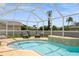 Sparkling pool with a jacuzzi, lounge chairs, and screened enclosure at 26115 Rampart Blvd, Punta Gorda, FL 33983