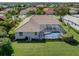 Aerial view of a residence with a screened-in pool and lush green lawn at 2928 Seasons Blvd, Sarasota, FL 34240