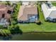 Backyard featuring a screened-in pool and lush green lawn extending to the water at 2928 Seasons Blvd, Sarasota, FL 34240