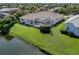 Aerial view of a screened-in pool and lush backyard extending to the water at 2928 Seasons Blvd, Sarasota, FL 34240