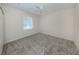 This is a bedroom with neutral colored walls, gray carpeting and a large window at 2928 Seasons Blvd, Sarasota, FL 34240