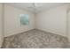 This is a bedroom with neutral colored walls, gray carpeting and a large window at 2928 Seasons Blvd, Sarasota, FL 34240