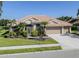 Inviting single-story home featuring a well-manicured lawn, mature landscaping, and a three-car garage at 2928 Seasons Blvd, Sarasota, FL 34240