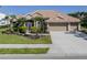 Charming single-story home with a well-manicured lawn, lush landscaping, and a tile roof at 2928 Seasons Blvd, Sarasota, FL 34240