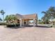 A welcoming community gatehouse entrance with a tiled roof and well-maintained landscaping at 2928 Seasons Blvd, Sarasota, FL 34240